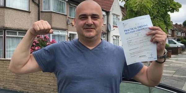 A driver instructor with a test certificate in hand