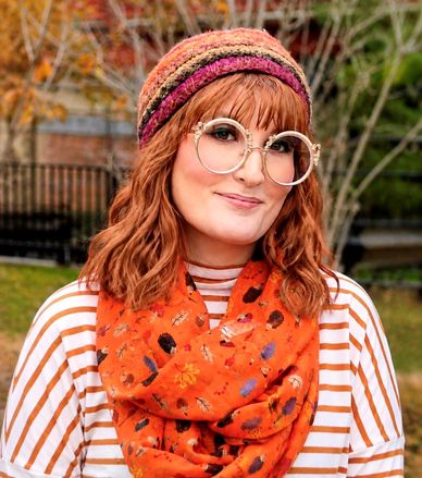 Woman with round glasses and autumn outfit.