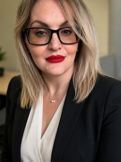 Professional woman with glasses and red lipstick.