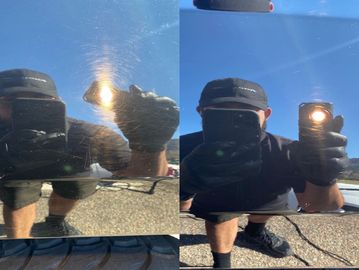 Person examining car paint with light.
