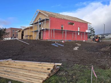 Partially constructed building with scaffolding and loose lumber.