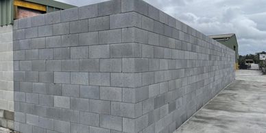 Long gray concrete block wall outdoors.