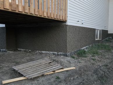 Newly constructed house foundation with soil around it.