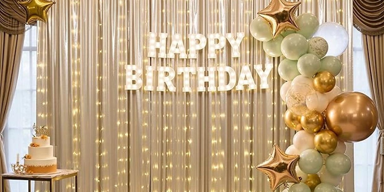 Elegant birthday setup with lights, balloons, and cake.