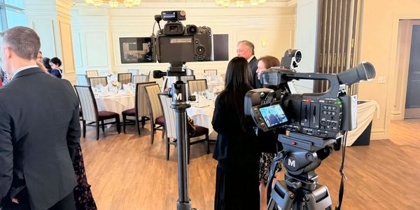 Professional cameras set up in an elegant event hall with guests.