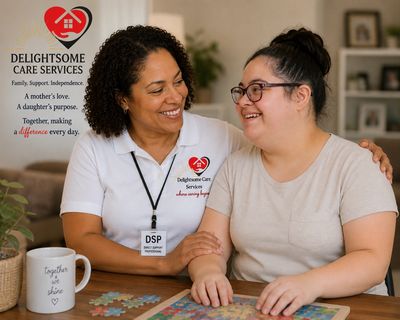 A DSP caregiver warmly supporting a smiling young woman at a table with a puzzle.