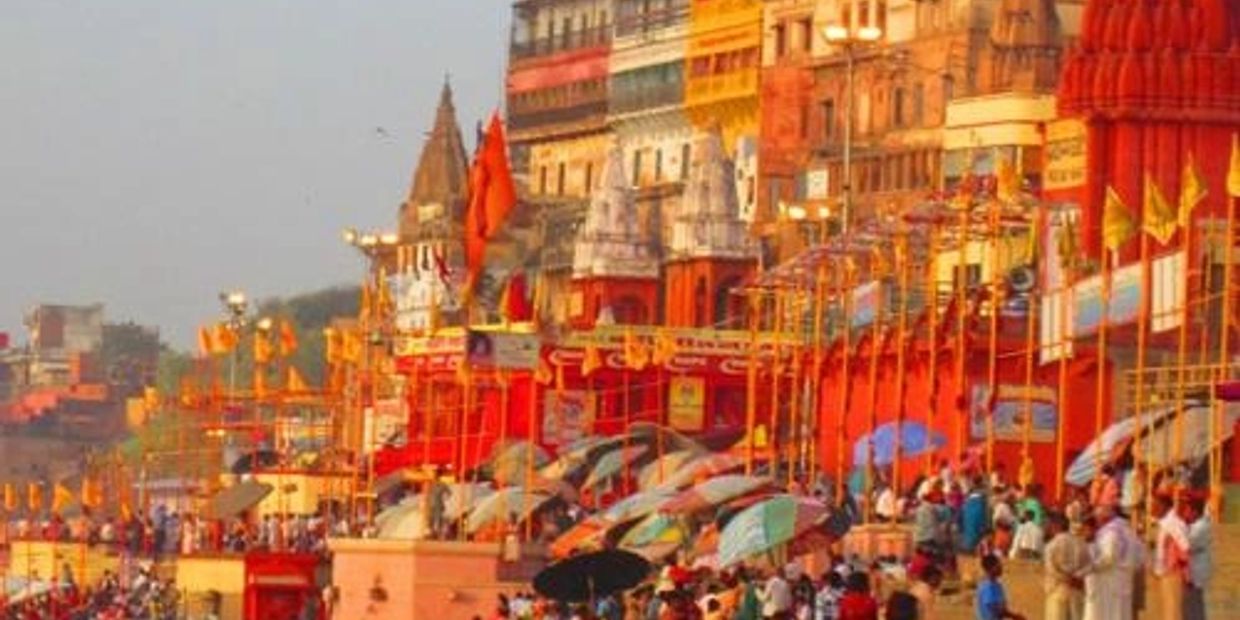 Busy riverside with colorful buildings and people.