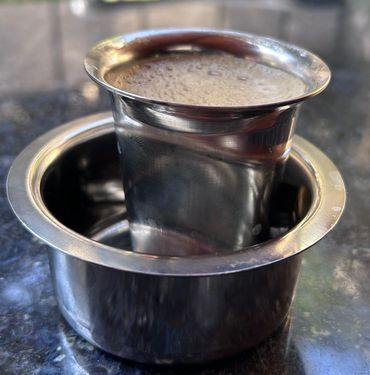 Traditional South Indian filter coffee served in a stainless steel tumbler and davara.