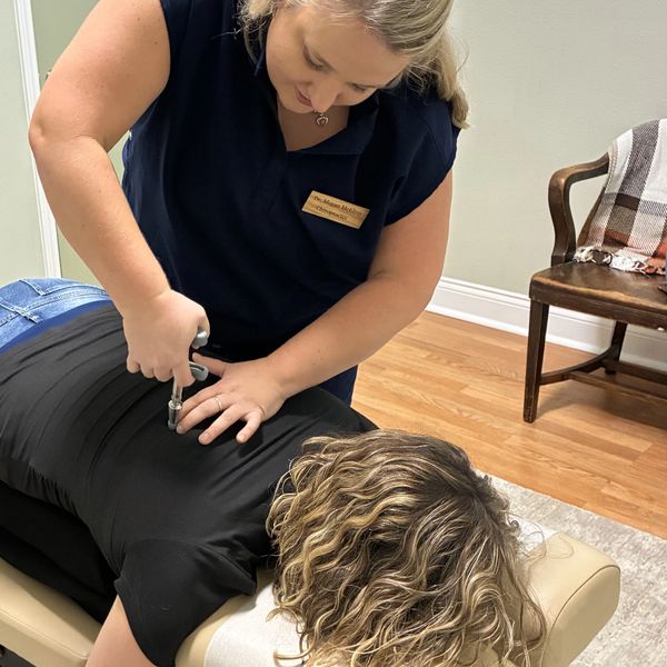 Chiropractor adjusting a patient on a treatment table.