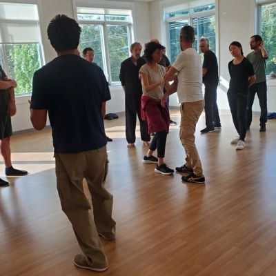 A group of people practicing dance in a bright studio.