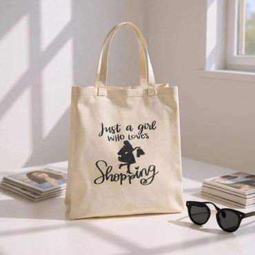 Beige tote bag with "Just a girl who loves shopping" text and silhouette design.