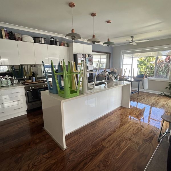 Modern kitchen with colorful stools placed upside down on the island.