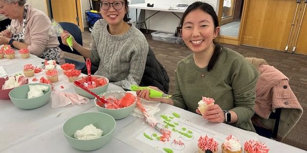 3 students smiling holding their cupcakes they are designing