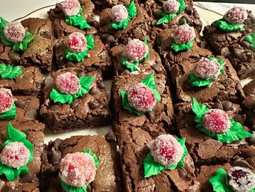 A platter of brownies decorated with candied cranberries.