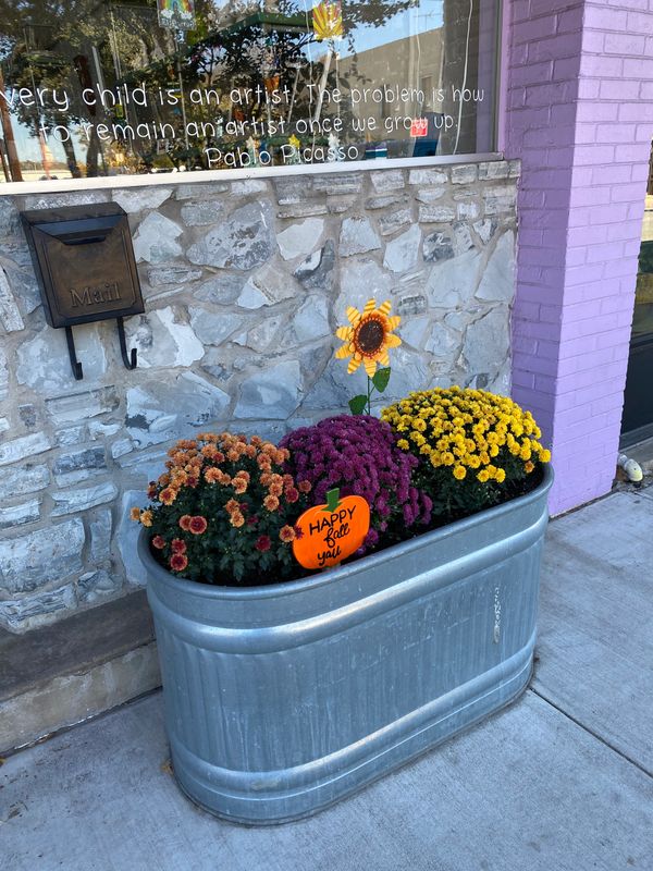 A flower bed with a pumpkin as a sign