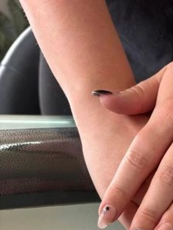 Hands with manicured nails featuring black and nude polish with star designs.