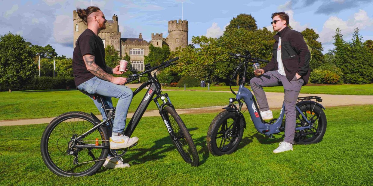 two men sitting on electric bikes in from of Malahide castle