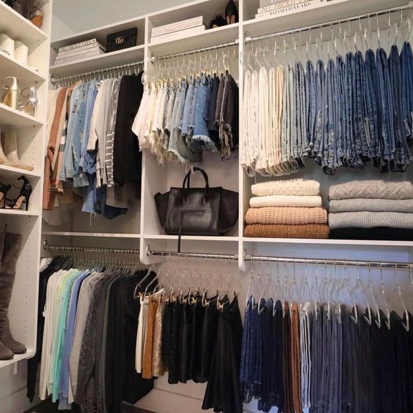 Organized closet with neatly hung clothes and shoes.