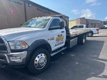 White Ram 5500 tow truck from Eagle Towing parked outside a printing services building.
