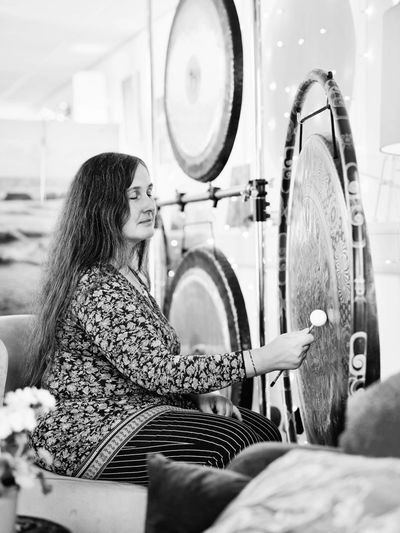 Masha playing a gong using a friction mallet