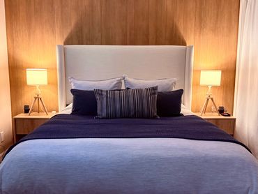 Cozy bedroom with a neatly made bed and warm lighting.