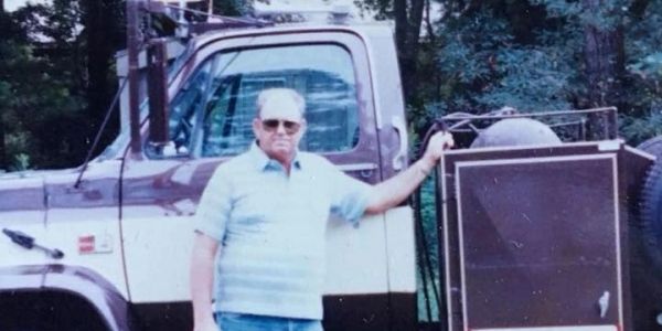 Great-grandfather Norman F Simmons Sr standing next to his toter.