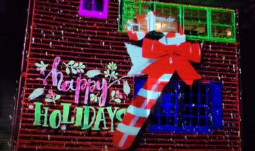 Festive holiday projection with candy cane and 'Happy Holidays' text.