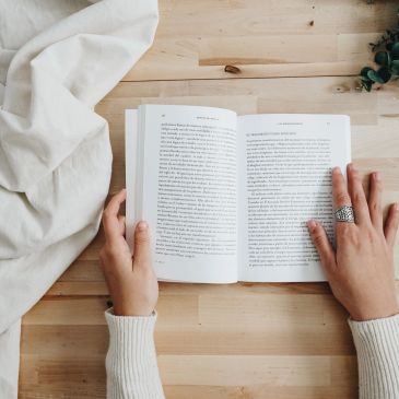 Person reading a book at home.