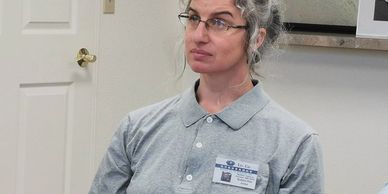 Bobbie Rae Jones sitting with a gray button-up shirt looking intently