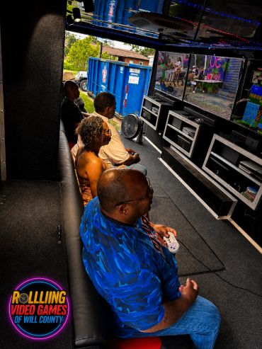 A group of people playing video games inside a mobile gaming truck.
