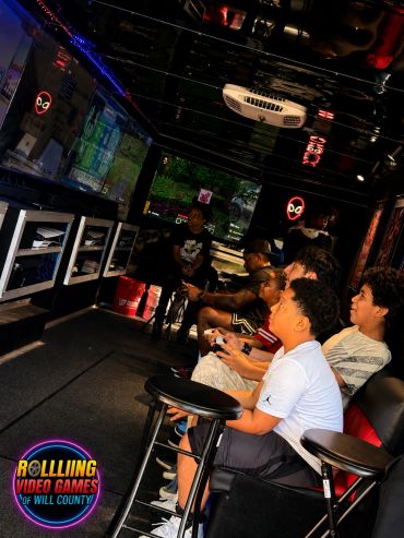 Kids intensely playing video games inside a gaming truck.
