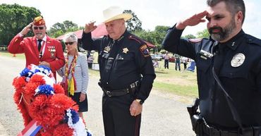 Retired Col Tony Poletti, paymaster escorts Charla Ann King, whose husband the late Marine Sgt Timot