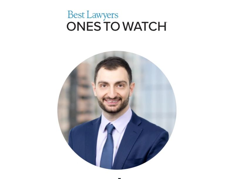Professional portrait of a young lawyer in a suit and tie.