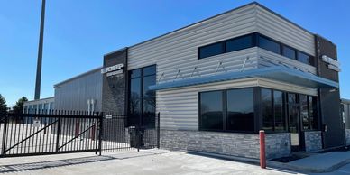 Modern industrial building with a gated entrance on a sunny day.