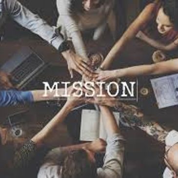 Teamwork with hands joined over table under the word 'MISSION'.