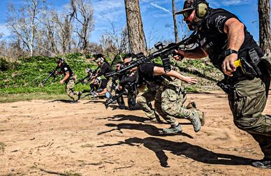 Group of men in tactical gear running with rifles.