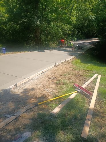 Workers smoothing a freshly poured driveway