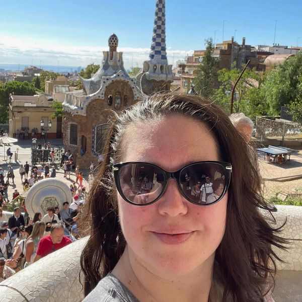 Woman taking selfie at a colorful park with unique architecture.