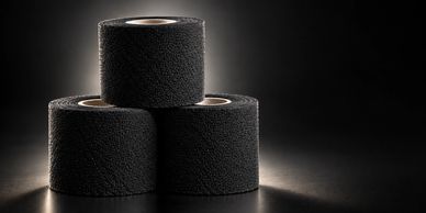 Three black rolls of tape stacked in a pyramid.