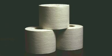 Three toilet paper rolls stacked against a dark background.