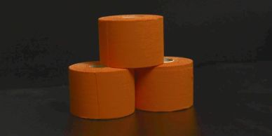 Three orange rolls of tape stacked in a pyramid.