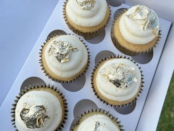 Cupcakes topped with gold leaf decoration.