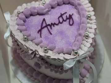 Heart-shaped purple cake with "Amity" written on top.