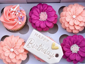Decorative flower cupcakes with a happy birthday tag.