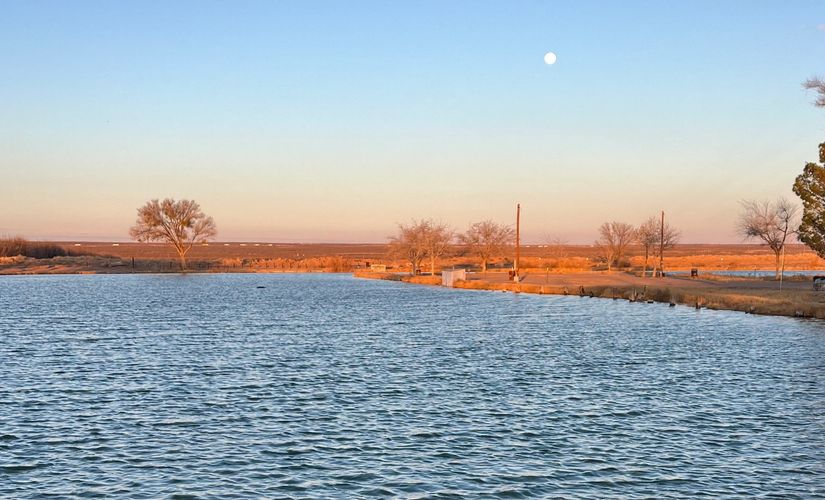 The moon rises over the horizon above the water at HideAway Lakes, TX.
