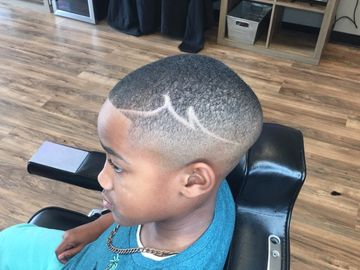 Boy with a fresh haircut featuring a unique zigzag design.