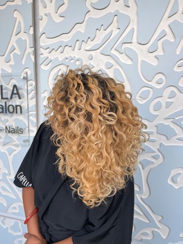 Honey golden blond highlights on natural curly hair.