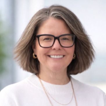 Smiling woman wearing glasses and white sweater.