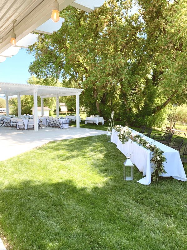 Outdoor garden event with long white table with flowers