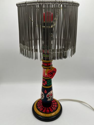 The lamp shade for this piece was made out of 100s of unused recycled tattoo needles, - - Michael Ca